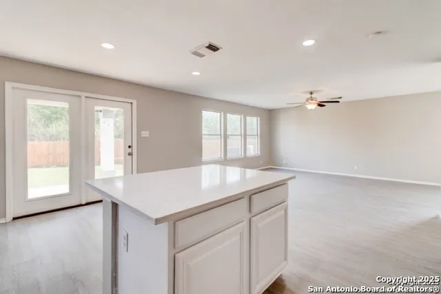 a kitchen with a sink chandelier and wooden floor