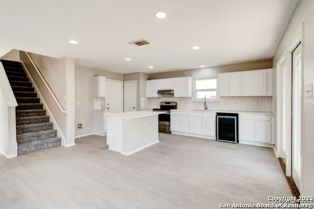 a view of a kitchen with wooden floor and electronic appliances