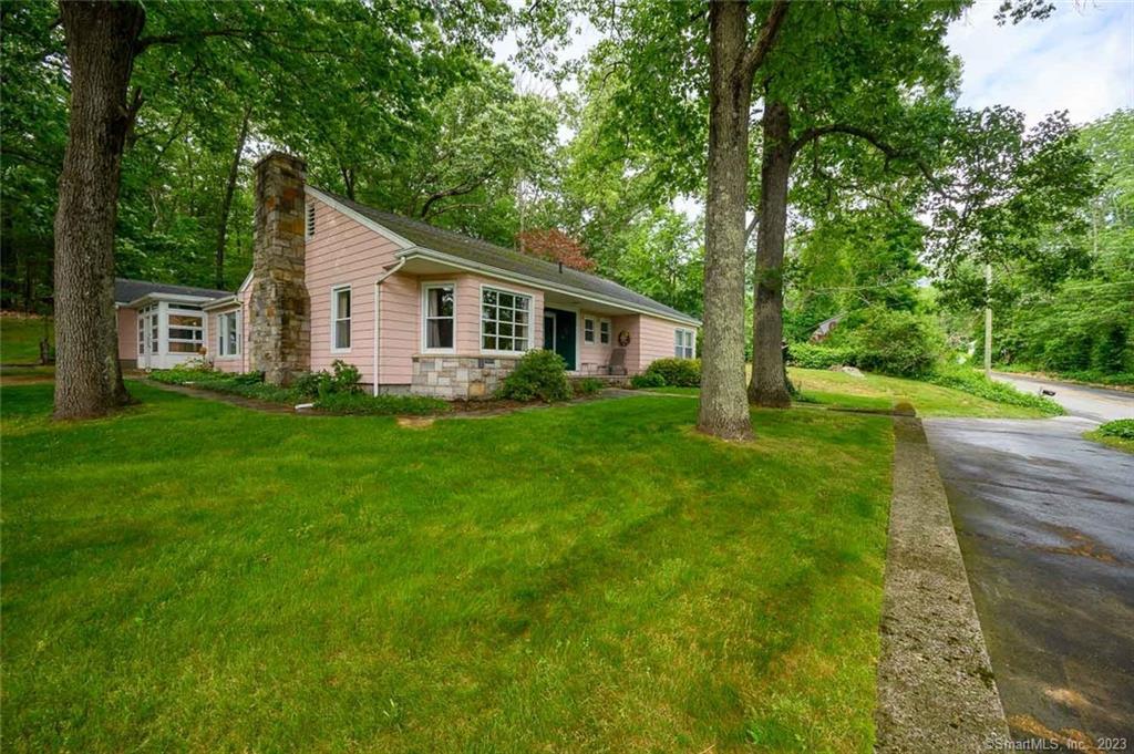 a view of a house with a yard and sitting area