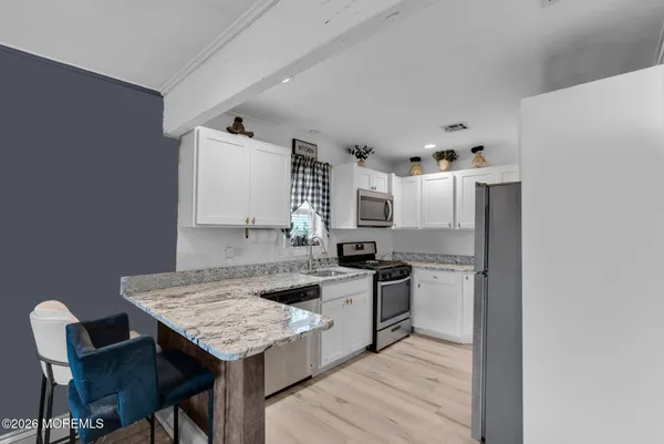 a kitchen with stainless steel appliances granite countertop a table chairs stove and refrigerator