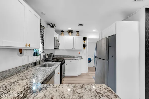 a kitchen with stainless steel appliances granite countertop a refrigerator a stove and a sink