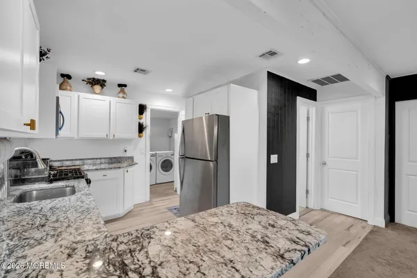 a kitchen with granite countertop a refrigerator stove and sink