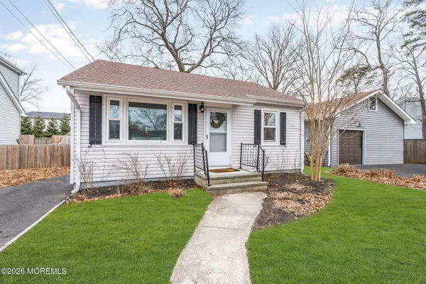 a view of a house with a yard and a large tree