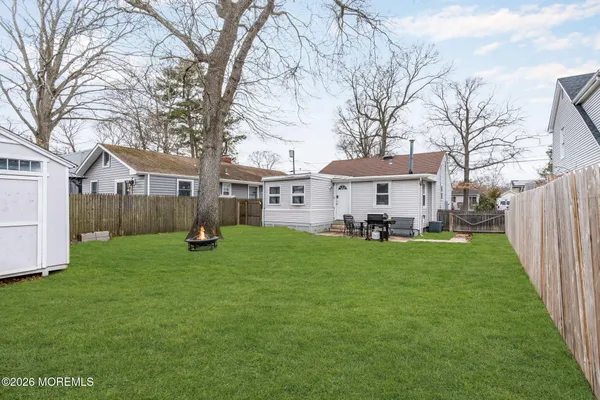 a view of a house with backyard and a tree