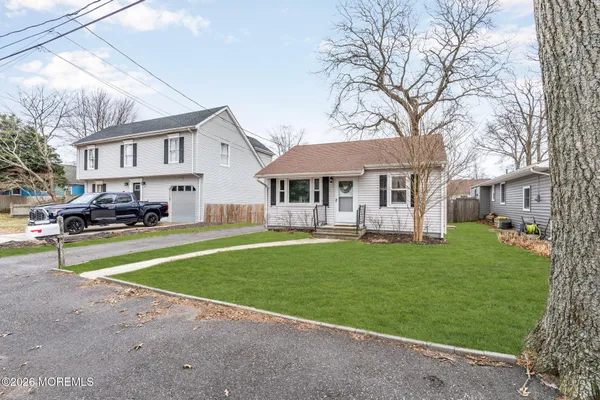 a front view of a house with a garden and trees