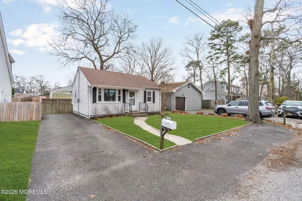 a view of a house with a yard and large trees