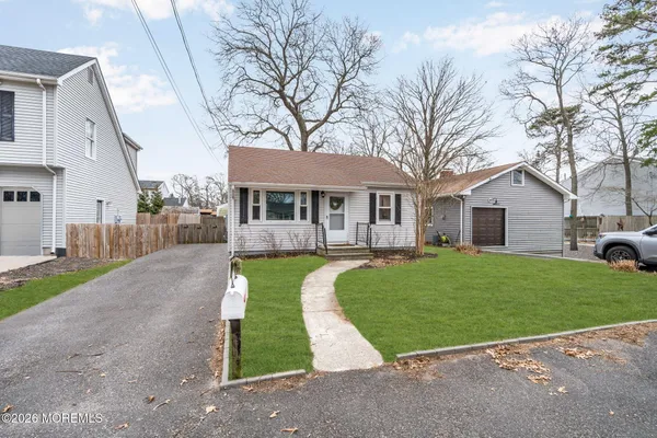 a view of a white house with a yard table and chairs