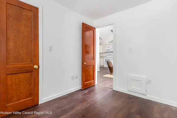 a view of a hallway with wooden floor and closet