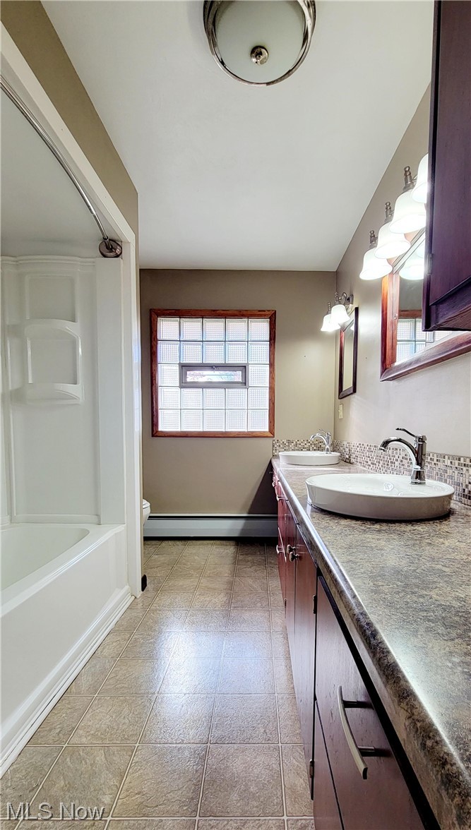 405 Bryan Road Milan, OH 44846 - Photo 16 of 35 Full bathroom with toilet, washtub / shower combination, a baseboard heating unit, tile floors, and vanity