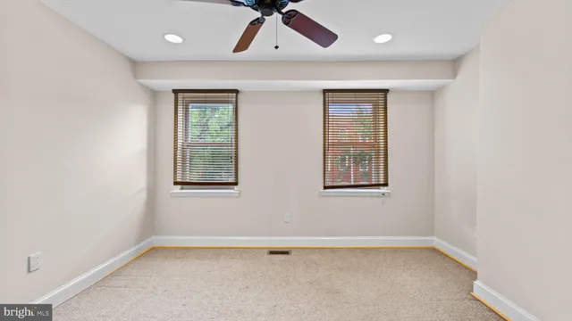 an empty room with a window and ceiling fan