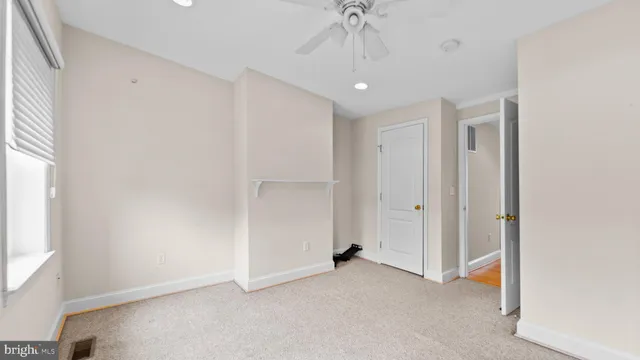 an empty room with a ceiling fan and a window