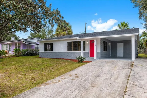 a view of a house with a yard and potted plants