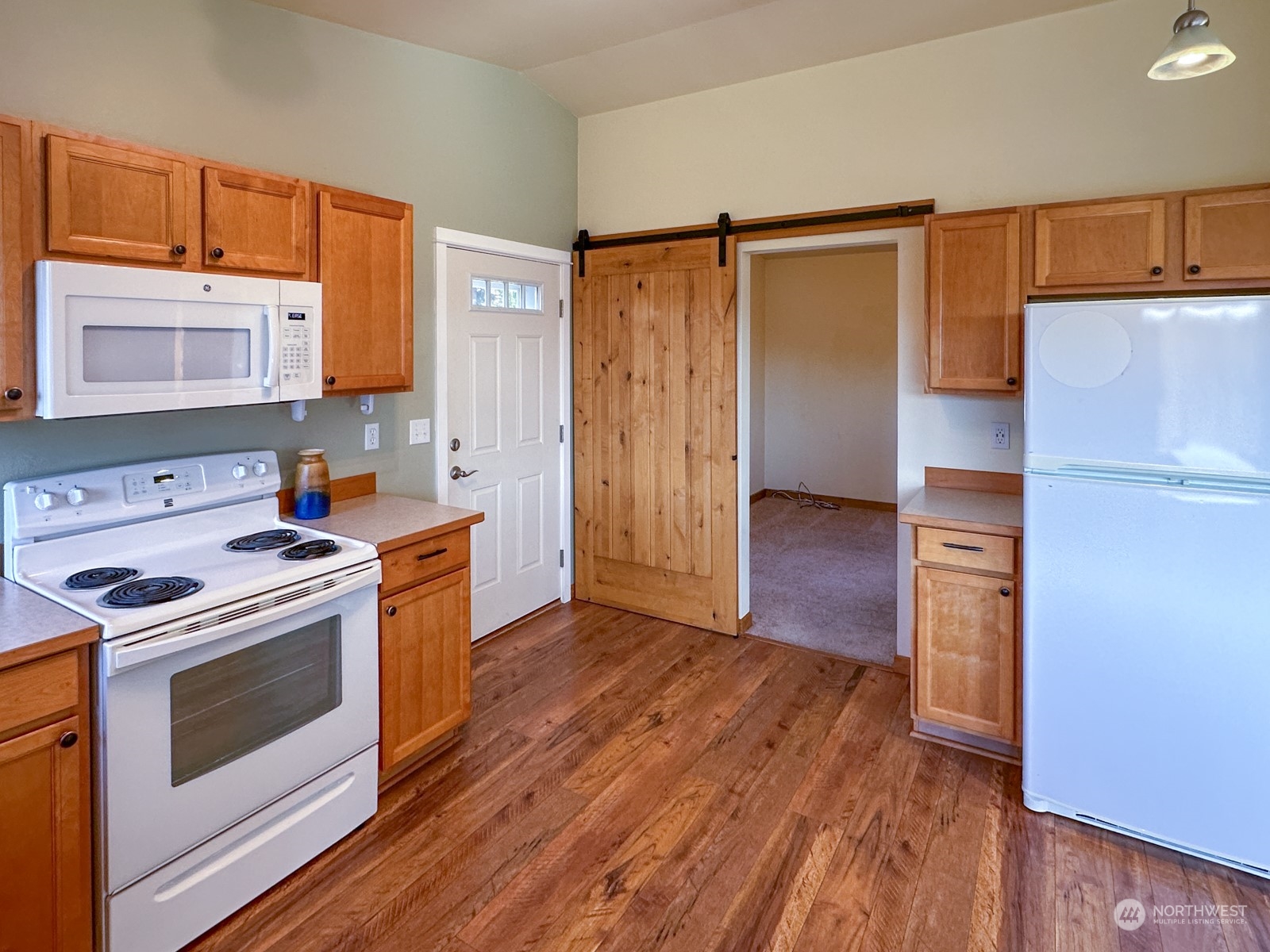 11243 Langworthy Road Southwest Rochester, WA 98579 - Photo 25 of 40 a kitchen with wooden floors and white stainless steel appliances