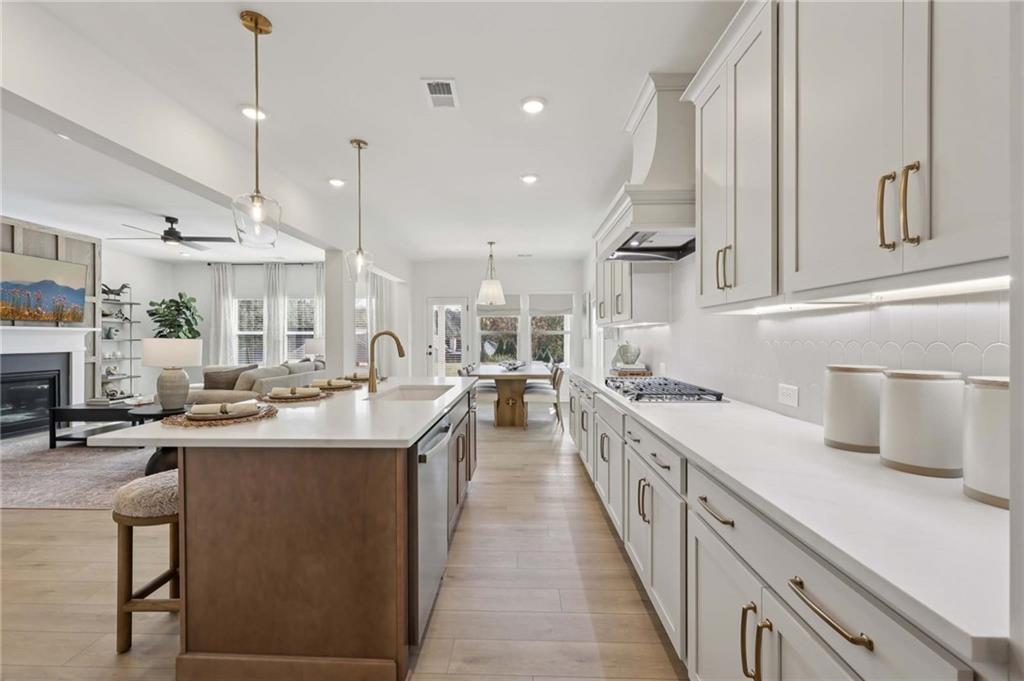 6205 Kismet Road Buford, GA 30518 - Photo 16 of 43 a kitchen with kitchen island a sink appliances and cabinets