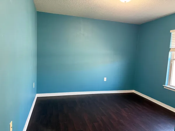an empty room with wooden floor and closet