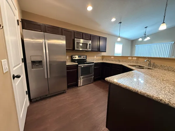 a kitchen with stainless steel appliances granite countertop a sink and stove