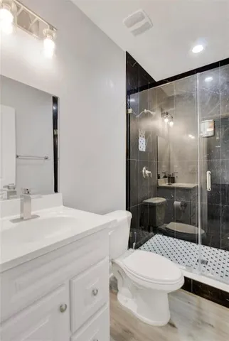 a bathroom with a sink a toilet and shower