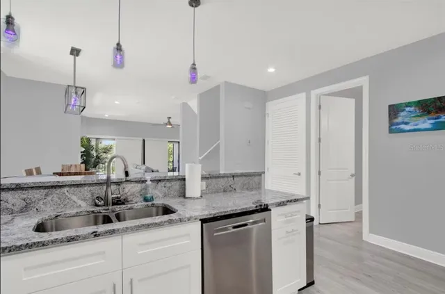 a kitchen with granite countertop white cabinets and black appliances