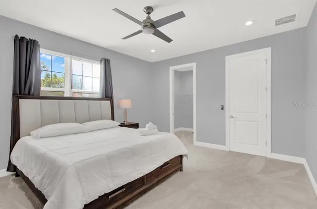 a bedroom with a bed chandelier and a window