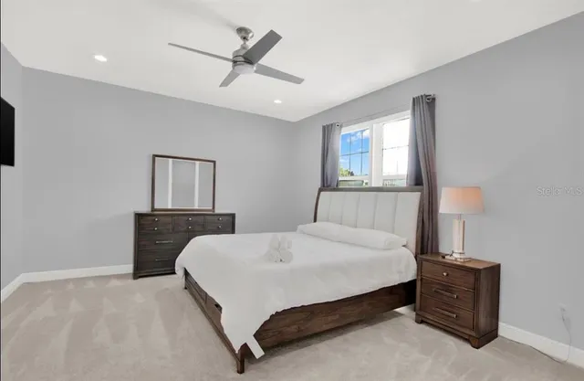 a bedroom with a bed a window and a ceiling fan