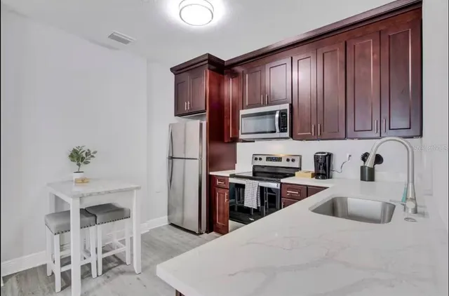 a kitchen with wooden cabinets and stainless steel appliances