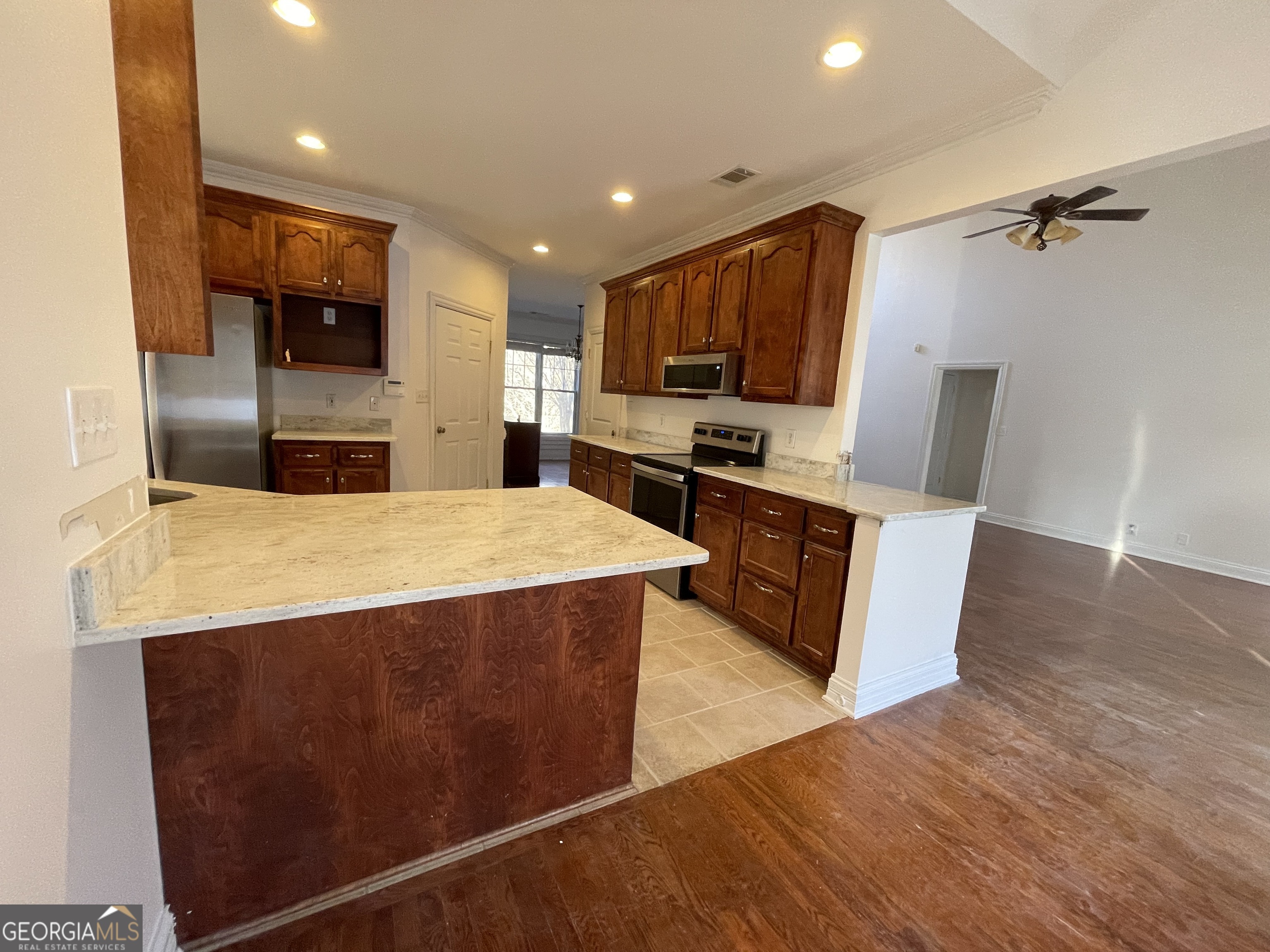 155 Rocky Way Williamson, GA 30292 - Photo 23 of 56 a large kitchen with stainless steel appliances a large counter top a stove a sink a microwave a refrigerator and a cabinets