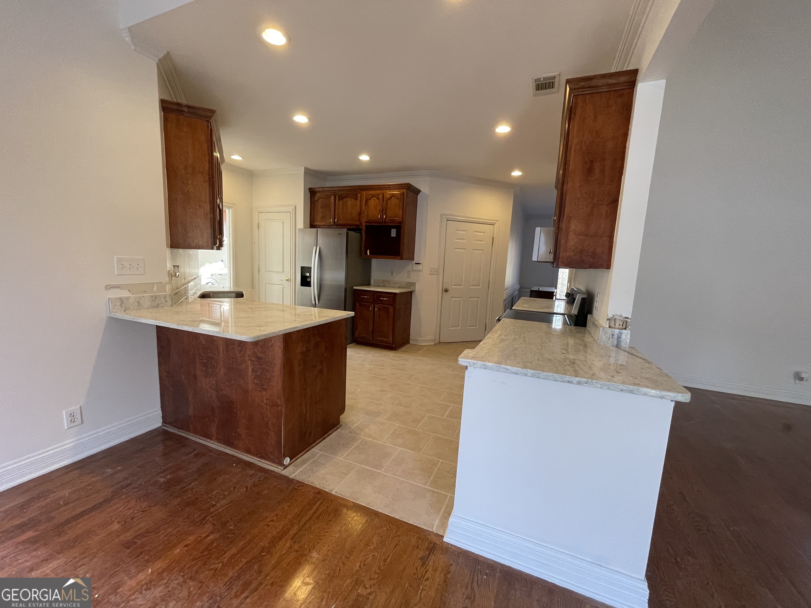 155 Rocky Way Williamson, GA 30292 - Photo 24 of 56 a kitchen with kitchen island a sink wooden floor and a counter top space