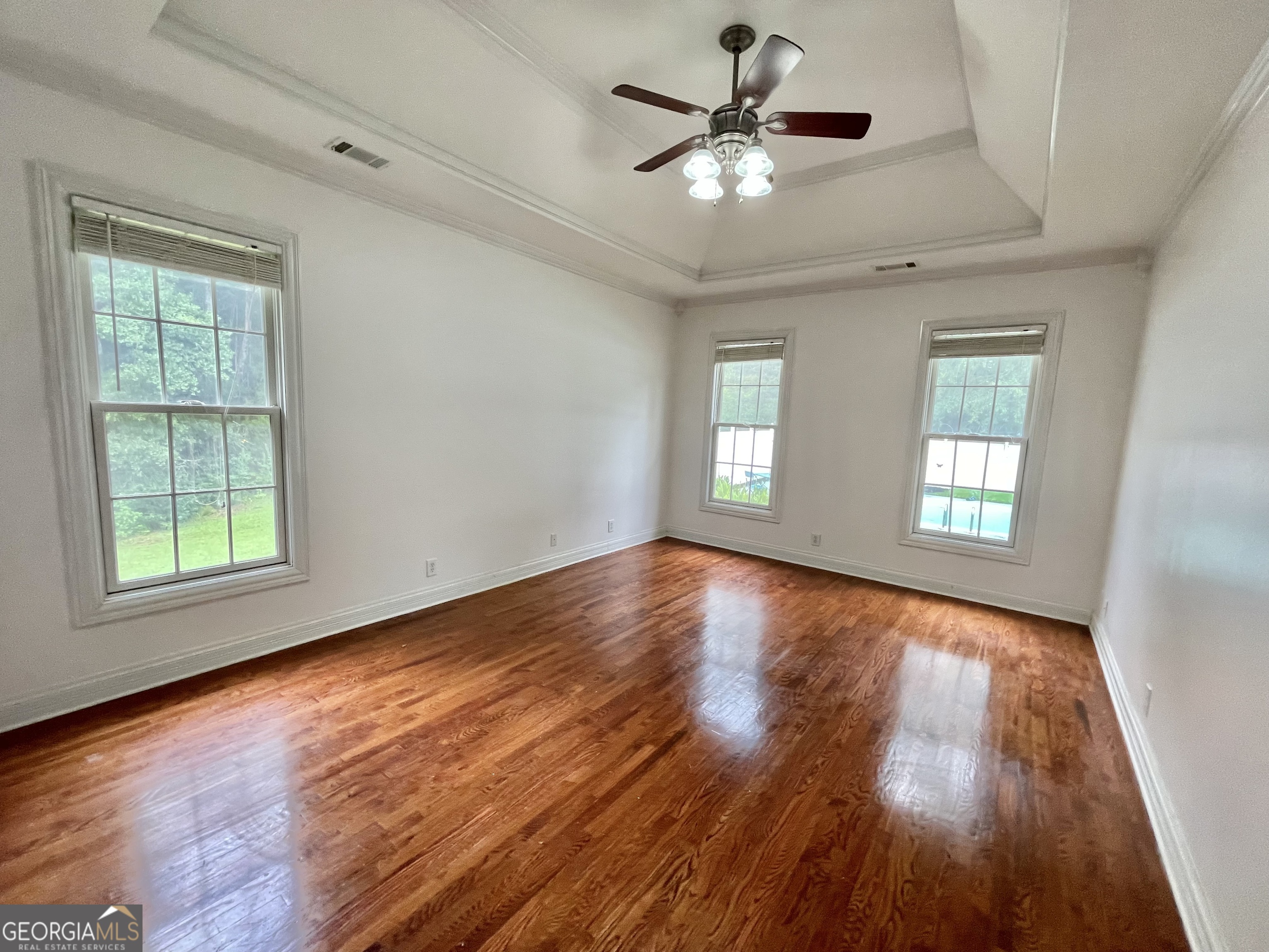 155 Rocky Way Williamson, GA 30292 - Photo 37 of 56 an empty room with wooden floor chandelier fan and windows
