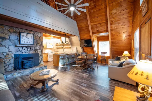 a living room with fireplace furniture and a large window