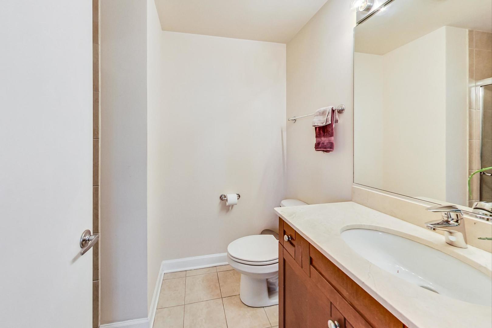 451 West Huron Street, Unit 1201 Chicago, IL 60654 - Photo 11 of 18 a bathroom with a sink a toilet and a mirror