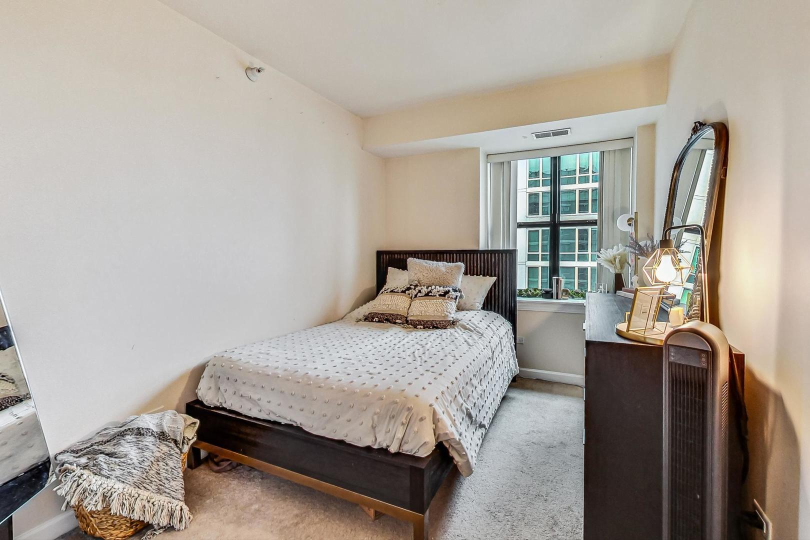 451 West Huron Street, Unit 1201 Chicago, IL 60654 - Photo 14 of 18 a bedroom with a bed dresser and a window