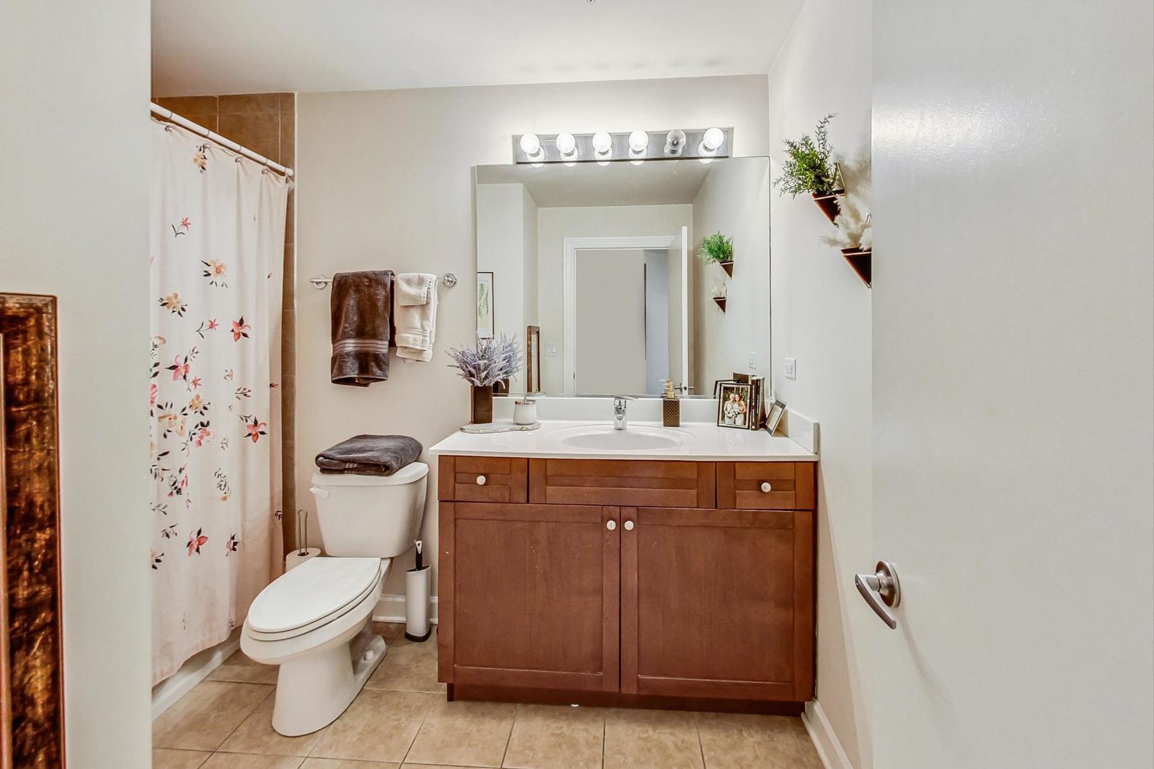 451 West Huron Street, Unit 1201 Chicago, IL 60654 - Photo 16 of 18 a bathroom with a granite countertop toilet sink and mirror