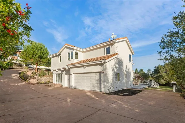 a view of a white house with a yard and garage
