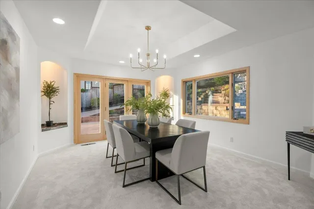 a dining room with furniture a chandelier and window