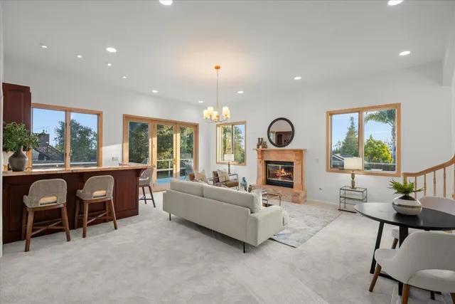 a living room with furniture a fireplace and a large window