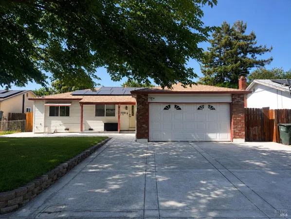 a front view of a house with a garden and trees