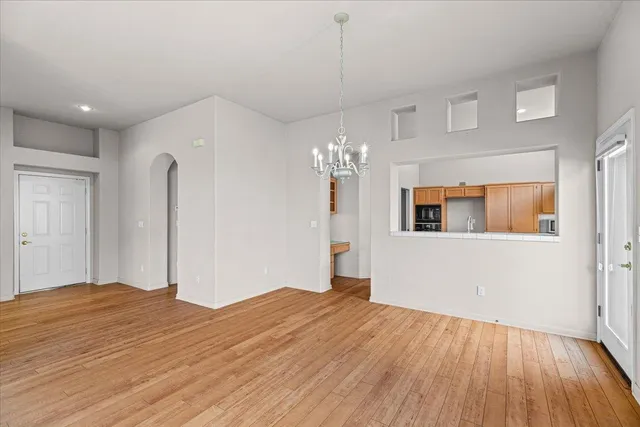 a kitchen with a sink wooden floor and an empty room