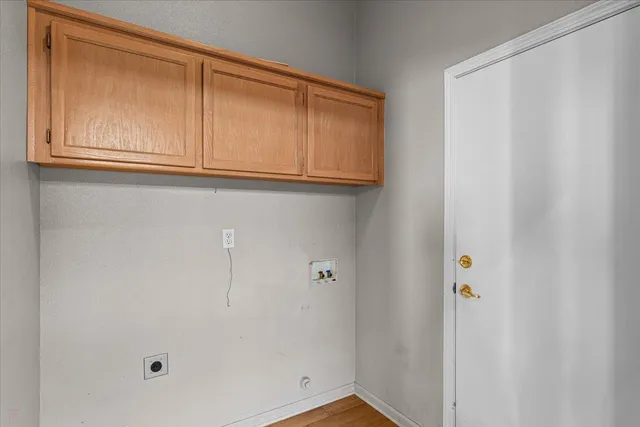 a view of an empty room with wooden floor and a fireplace