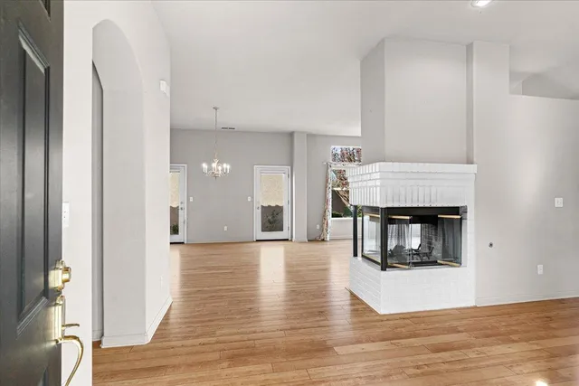 a view of an empty room with window and wooden floor