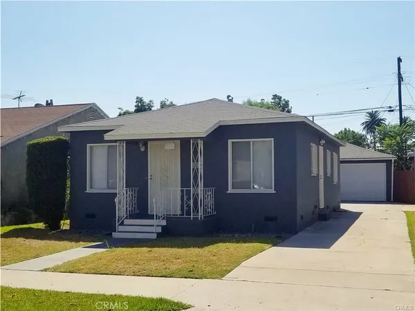 a view of a house with a patio and a yard