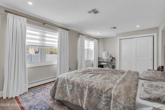 a spacious bedroom with a large bed and wooden floor