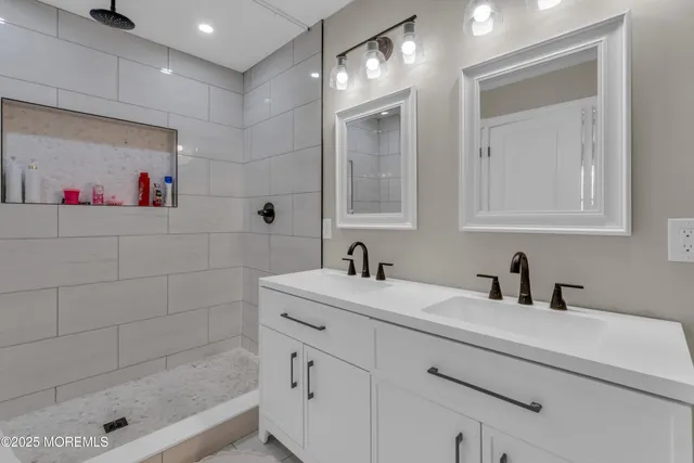 a bathroom with a sink a shower and a mirror