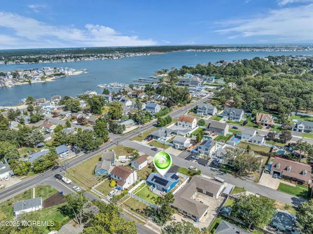 an aerial view of ocean and residential houses with outdoor space