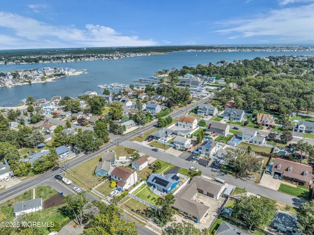 an aerial view of a city with lots of residential buildings ocean and mountain view in back