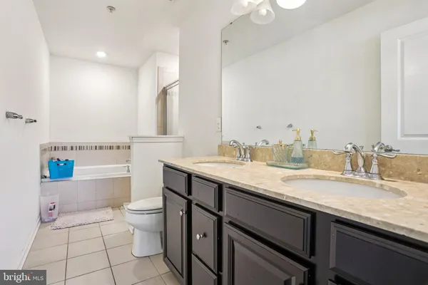a bathroom with a granite countertop sink a toilet and a mirror