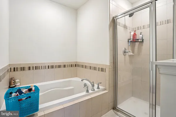 a bathroom with a bathtub a shower and a sink
