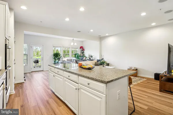 a kitchen with stainless steel appliances granite countertop a sink dishwasher and a stove with wooden floor