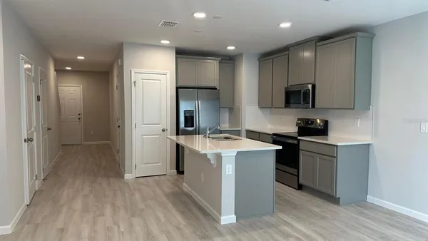 a kitchen with a sink a refrigerator and a stove top oven