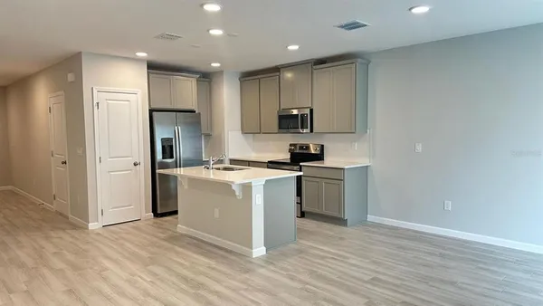 a kitchen with a refrigerator and a stove top oven