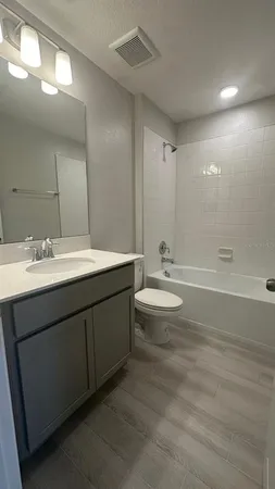 a bathroom with a granite countertop toilet and a sink